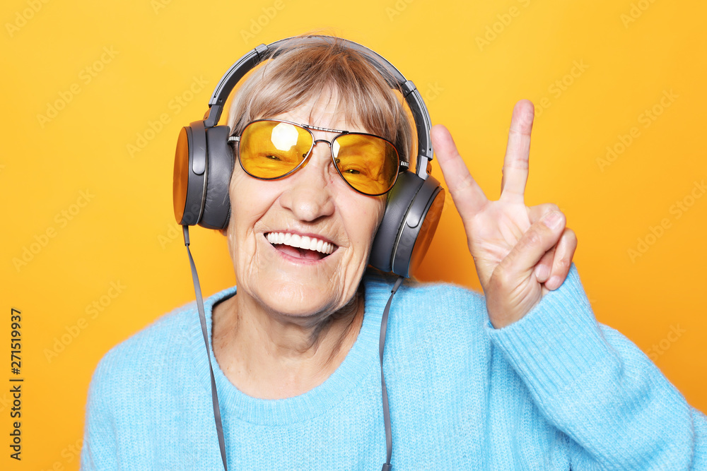 funny-old-lady-listening-music-and-showing-thumbs-up-stock-photo