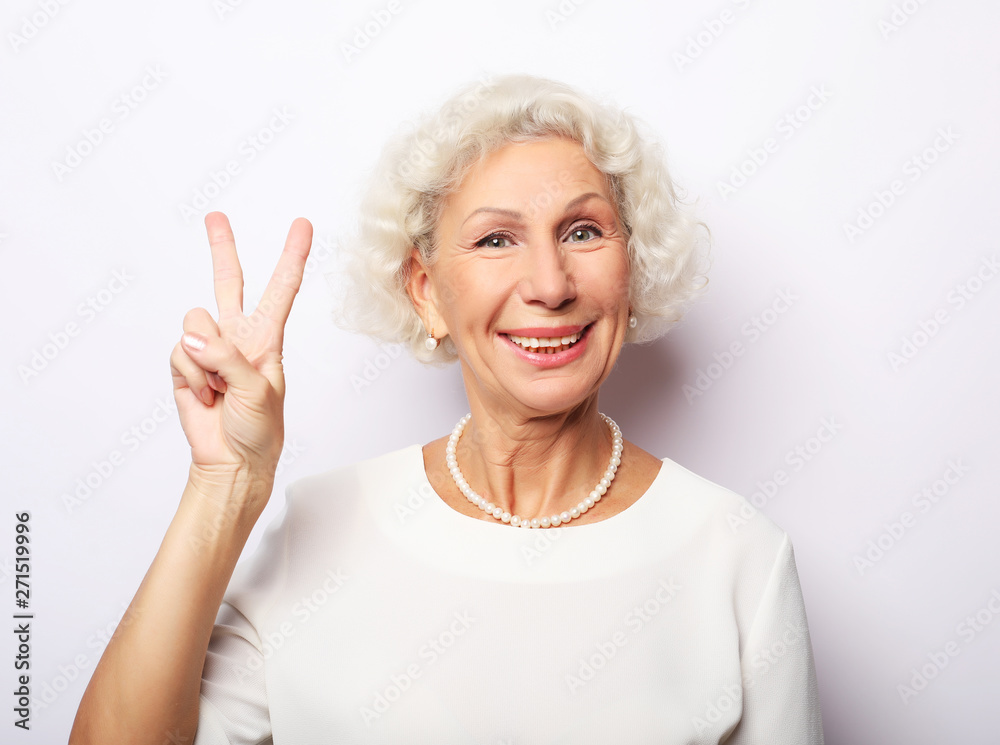 Old woman laugh and showing peace or victory signat camera. Emotion and feelings. Portrait of expressive grandmother. Old woman laugh and showing peace or victory signat camera. Emotion and feelings. Portrait of expressive grandmother.