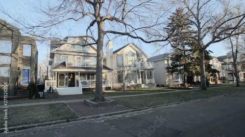View down a street of an established neighbourhood with houses and large trees; Edmonton, Alberta, Canada