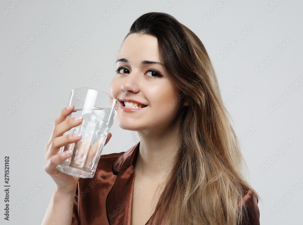 lifestyle and people concept - young woman wearing pajamas holding water glass lifestyle and people concept - young woman wearing pajamas holding water glass