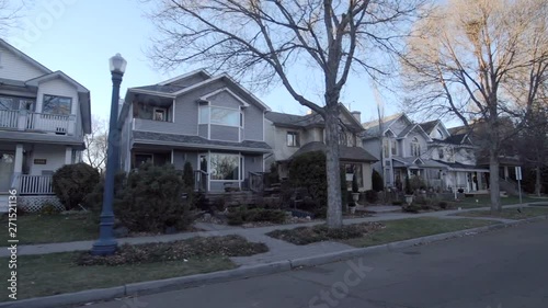 View down a street of an established neighbourhood with houses, porches and large trees; Edmonton, Alberta, Canada