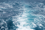 Water wake of cruise liner blue sea splash background.
