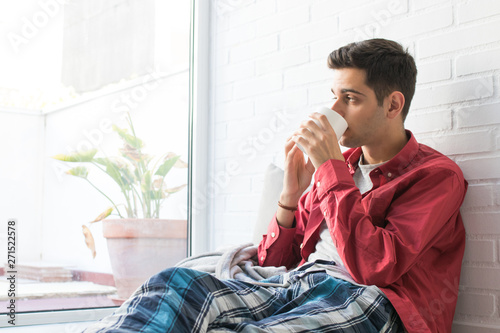 Wallpaper Mural young man eating breakfast or drinking coffee at home Torontodigital.ca