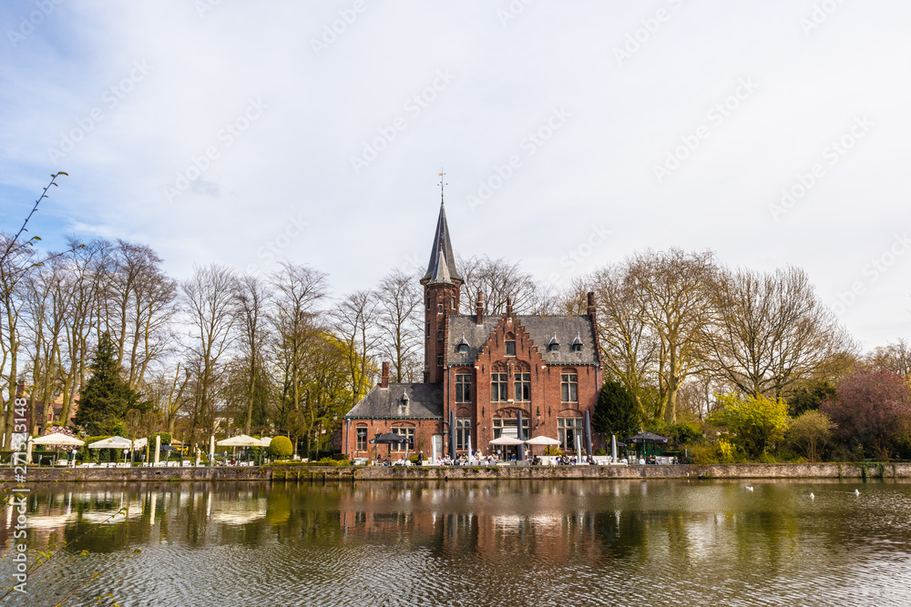 Bruges, Belgium - APRIL 05, 2019: Minnewater lake and medieval castle in Bruges