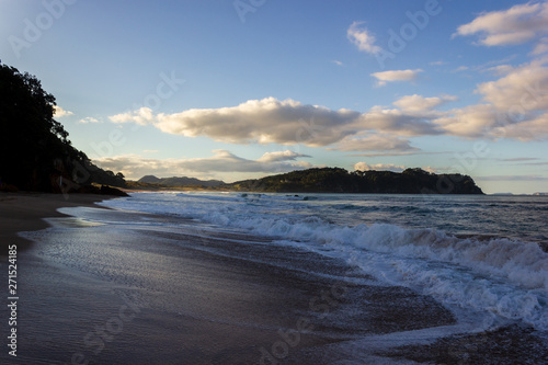 Sandy beach near New Zealand's hot water beach in mysterious evening scenery with calm pacific ocean