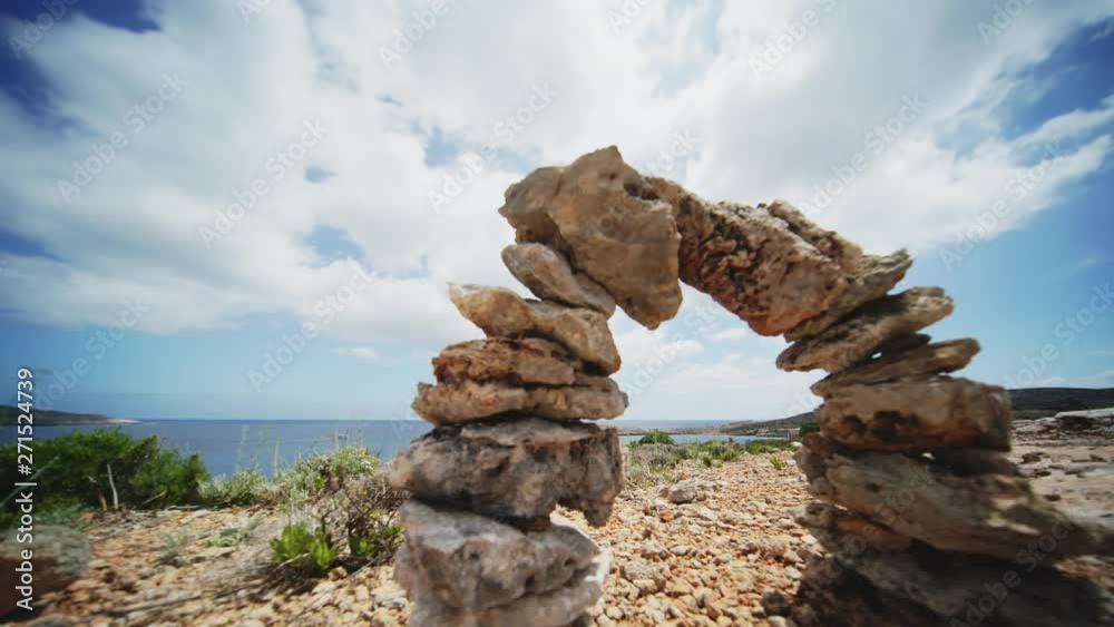 Balanced stone pyramid. Stacked stones pyramid on the background of floating clouds. arch time lapse Balanced stone pyramid. Stacked stones pyramid on the background of floating clouds. arch time lapse
