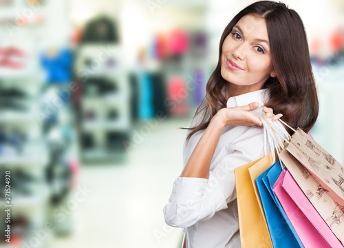 Young woman with shopping bags on blurred shopping mall background