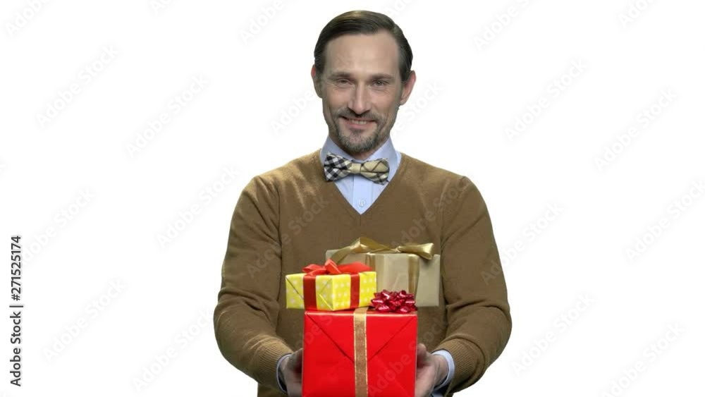 Handsome macho-man giving gift boxes. Playful middle-aged man handing holiday gifts. Birthday greeting background. Handsome macho-man giving gift boxes. Playful middle-aged man handing holiday gifts. Birthday greeting background.