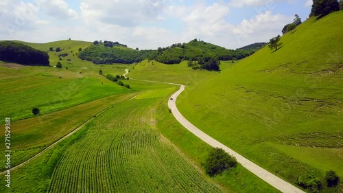 Aerial Footage of an relaxing and peaceful green landscape of a driving car on a countryside road surrounded by green hills in Transylvania. 4K. photo