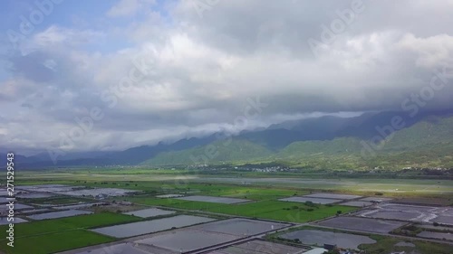 Aerial view of rice fields in Yuli, Hualien County, Taiwan. The area is located in the eastern rift valley, next to the famous Xiuguluan River, surrounded by layers of mountains. - Fly forward photo