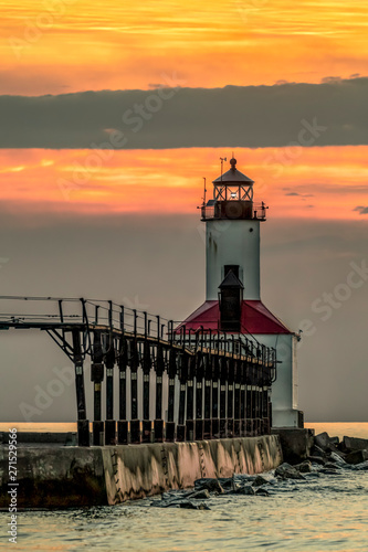 Near Sundown at Michigan City - The lighthouse on Lake Michigan at Michigan City, Indiana is backed by a cloudy and colorful sunset sky.