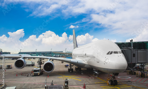 Airport view with Preparation of the airplane before flight and service vehicles on blue sky background.