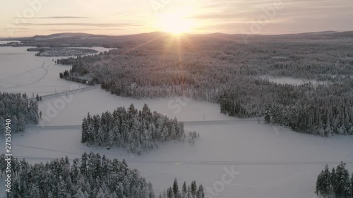 AERIAL : Sunset over a cold landscape. A smal village in Swedish lapland. photo