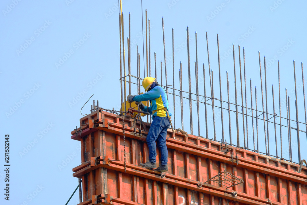 Foreman worker in safety uniform working on construction site with copy space
