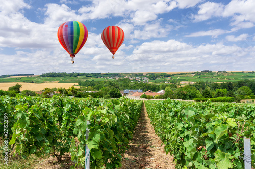 Fotografi Colorful hot air balloons flying over champagne Vineyards at sunset montagne de