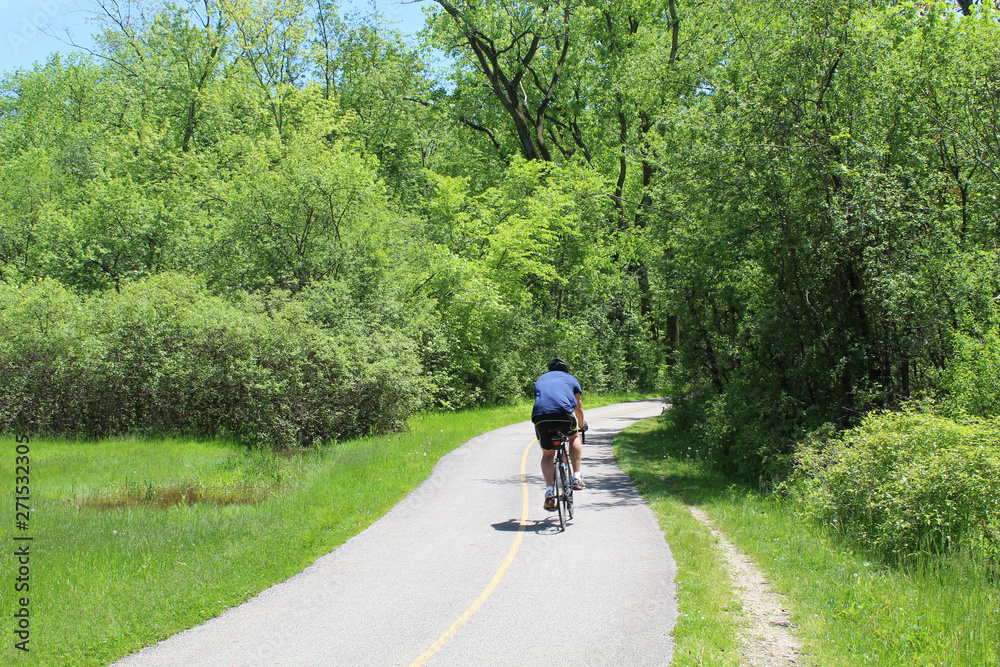 Man riding bicycle at Glenview, Illinois' Blue Star Memorial Woods