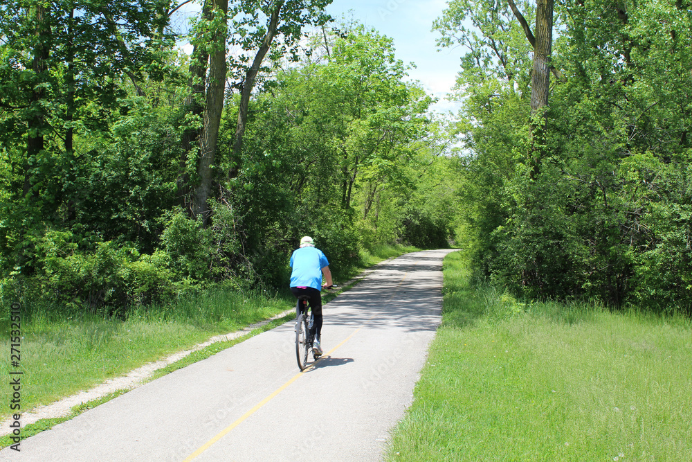 Fototapeta premium Older man riding a bicycle at Blue Star Memorial Woods in Glevniew, Illinois