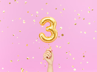 Three year birthday. Female hand holding Number 3 foil balloon. Tree-year anniversary background. 3d rendering