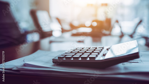 Close up calculator on business working desk, dark background. photo