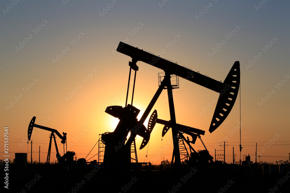 The pumping unit is working in the setting sun The pumping unit is working in the setting sun