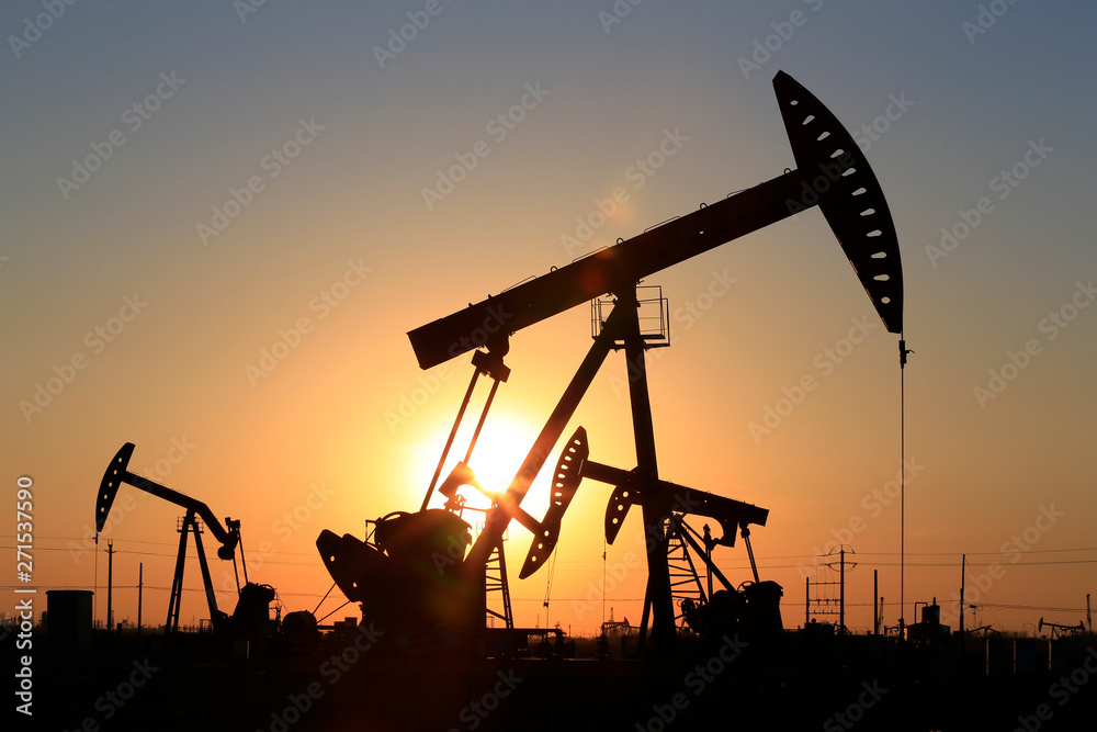 The pumping unit is working in the setting sun The pumping unit is working in the setting sun