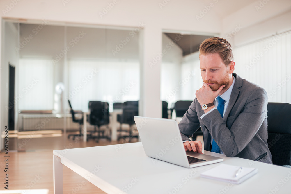 Young businessman pondering over ideas for new business project.