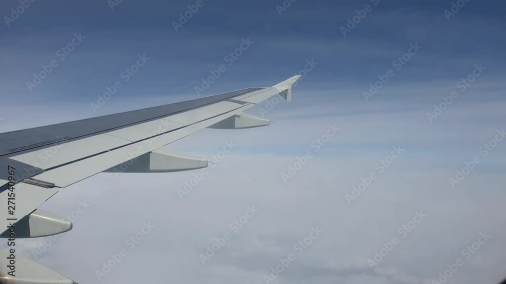 Reverse Shot Looking Out The Window Of Airplane Flying Above The Clouds In A Beautiful Blue Sky - 4k 30fps