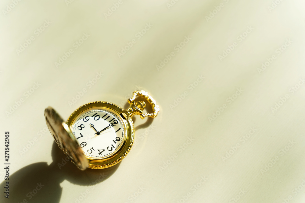 Time background concept. Golden pocket watch on table with sunlight and free copy space for text. Time background concept. Golden pocket watch on table with sunlight and free copy space for text.