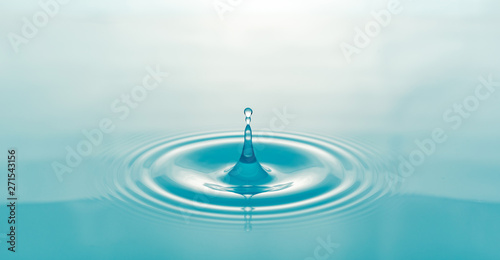 One blue drop of water on surface of water background