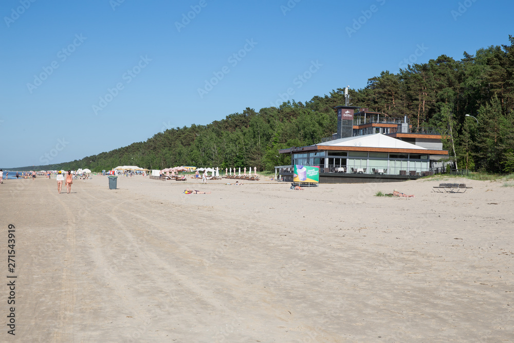 Fototapeta premium City Jurmala, Latvian Republic. Peoples walking on sand beach and sunbathing. Travel photo. 2019. 4. Jun.