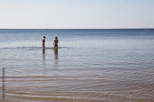 City Jurmala, Latvian Republic. Girls go swimming in the Baltic Sea. Water and waves. Travel photo. 2019. 4. Jun