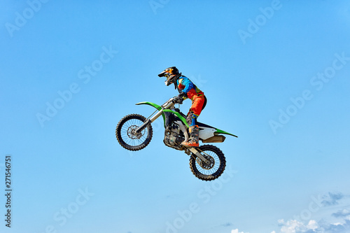 Fototapeta Naklejka Na Ścianę i Meble -  Extreme sports, motorcycle jumping. Motorcyclist makes an extreme jump against the sky.