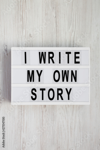 'I write my own story' words on a lightbox on a white wooden background. From above, overhead, flat lay, top view.