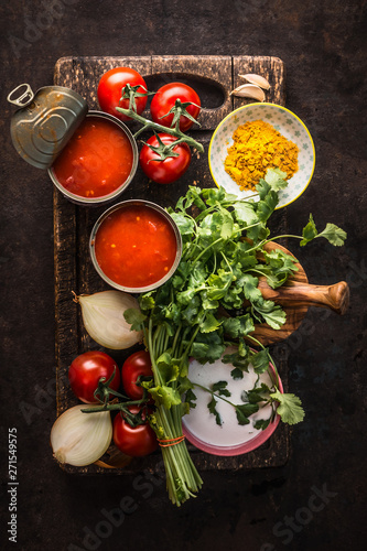 Healthy fresh ingredients for tomato soup on dark rustic kitchen table background, top view