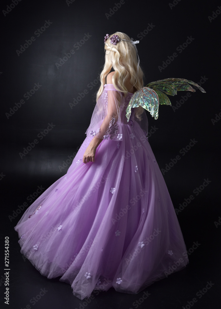 full length portrait of a blonde girl wearing a fantasy fairy inspired  costume, long purple ball