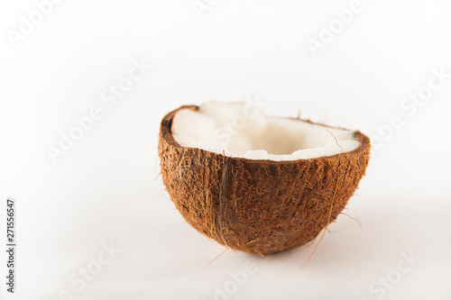 Coconut cut in half isolated on white background. Coconut milk and pulp close-up and copy space.