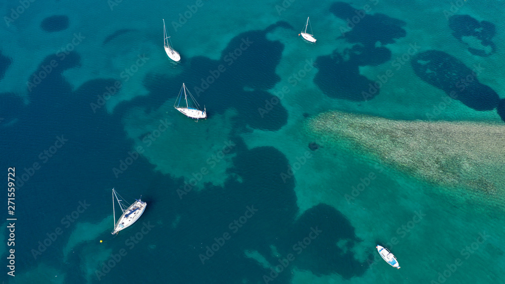Obraz premium Aerial drone bird's eye top view photo of traditional fishing boats in island of Mykonos, Cyclades, Greece