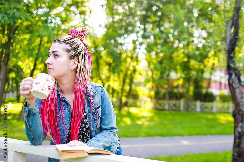 beautiful woman with pink dreadlocks in the park