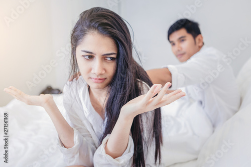 Frustrated young couple with serious relationship problems on the bed