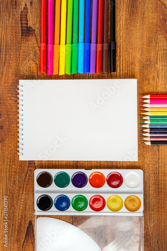colorful pencils, markers and watercolor composition mock-up Back to school concept with stationery office supplies on a brown wooden background with copy space top view