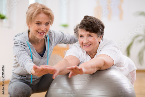 Female physiotherapist working out with senior patient in clinic photo