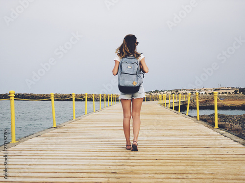 Single woman near the ocean / sea on a wooden pier.