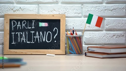 Do you speak Italian written on board, hand putting Italy flag in box, language photo