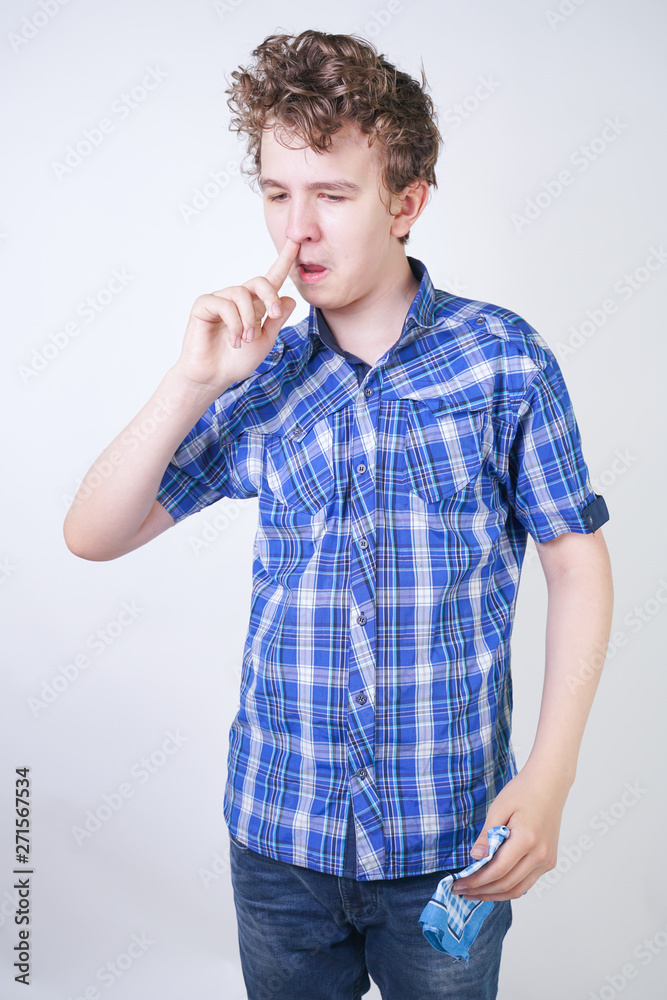Allergy Boy Child with runny nose holding a handkerchief. Teenager is having bad health and standing on white studio background alone. Allergy Boy Child with runny nose holding a handkerchief. Teenager is having bad health and standing on white studio background alone.
