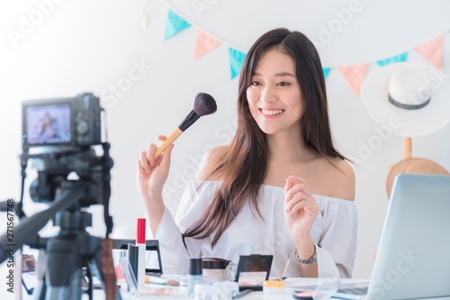 Fotografie Asian beautiful woman blogger is showing how to make up and use cosmetic