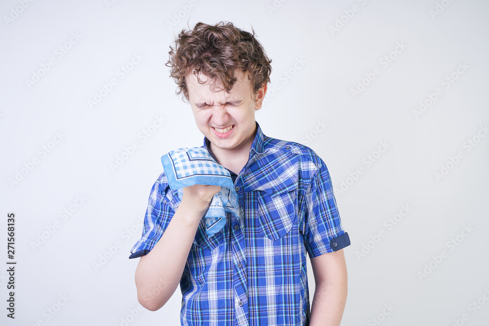 Allergy Boy Child with runny nose holding a handkerchief. Teenager is having bad health and standing on white studio background alone. Allergy Boy Child with runny nose holding a handkerchief. Teenager is having bad health and standing on white studio background alone.