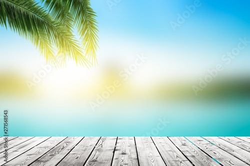 World Oceans Day concept  Empty wooden board on Palm leaves and Abstract blurred  beach with  sunset sky background