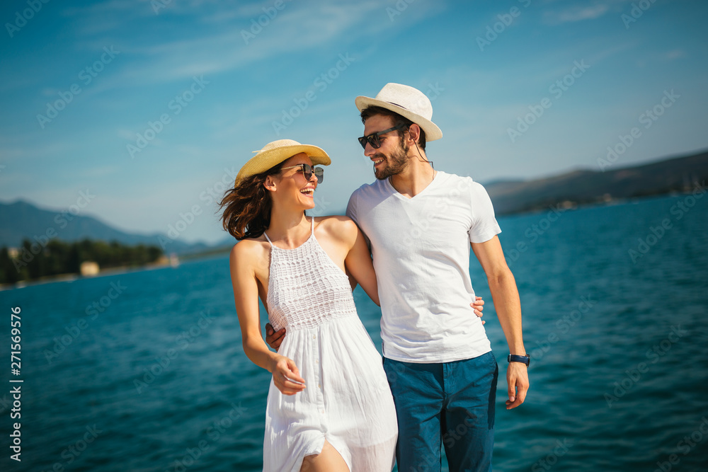 Young beautiful tourist couple enjoying summer holiday on the seaside Young beautiful tourist couple enjoying summer holiday on the seaside