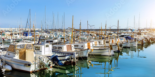Private yachts and fishing boats moored at pier in seaport Blanes. Sailing and motor boats are moored at seawall. Vessels with catch of sea fish delicacies. Marina Blanes, Spain, Costa Brava © Александр Чернышов