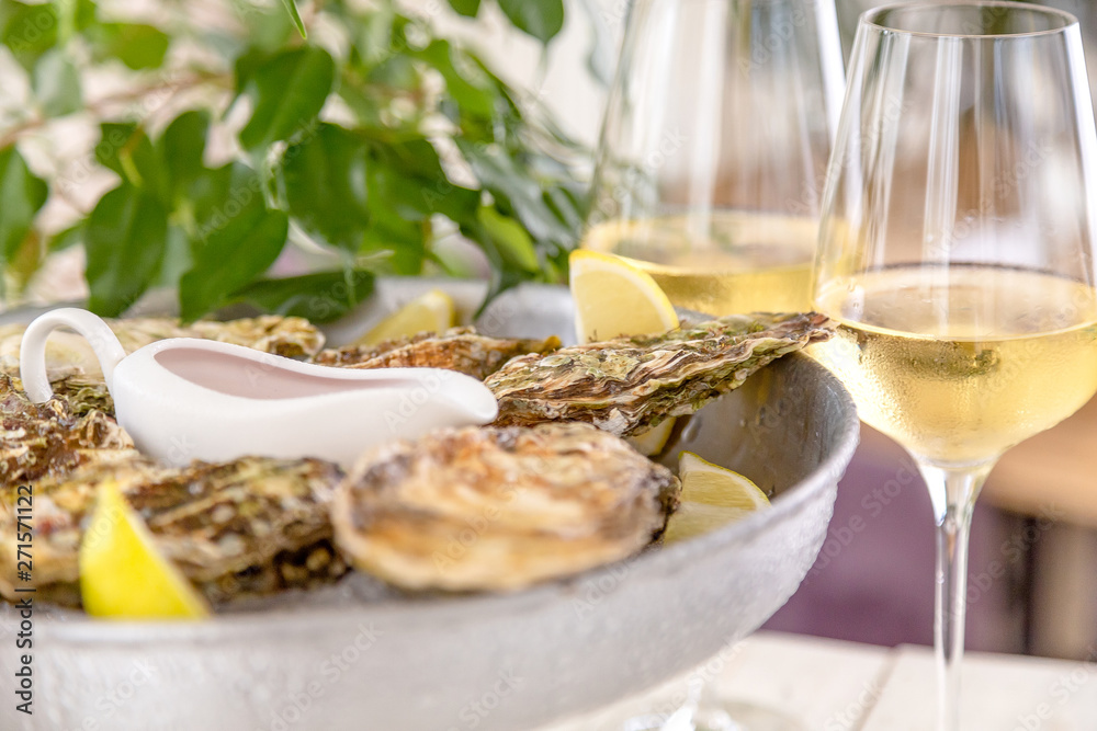 Fresh oysters with ice and white wine. Seafood. White background
